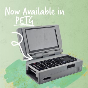 May include: A gray handheld computer with a screen and keyboard. The text "Now Available in PETG" is written in white above the computer. The background is a light green with brushstroke-like patterns.