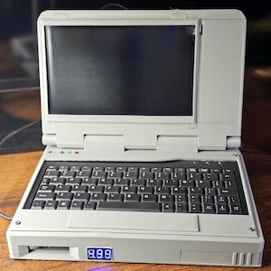 May include: A gray laptop computer with a black keyboard and a blue digital display that reads "888".