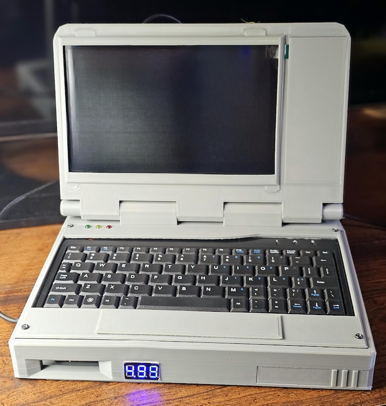 May include: A gray laptop computer with a black keyboard and a blue digital display that reads "888".