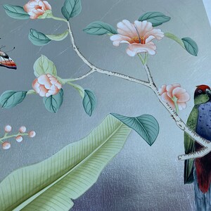 May include: A decorative panel with a silver background featuring a painted floral and fauna design. The artwork includes peach-colored flowers, green leaves, a colorful butterfly, and a bird perched on a branch. The overall aesthetic is elegant and nature-inspired.