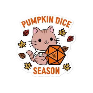 Può includere: Un adesivo con un gatto dei cartoni animati con una sciarpa, che tiene un dado D20 arancione. Il testo "PUMPKIN DICE SEASON" è arcuato sopra e sotto il gatto. Foglie autunnali arancioni, gialle e marroni circondano il gatto.