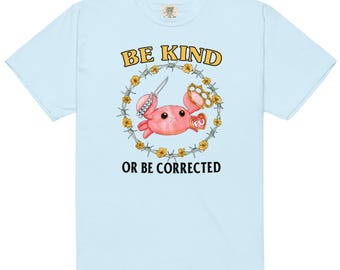 May include: Light blue t-shirt featuring a cartoon crab with a knife and brass knuckles, surrounded by a barbed wire and flower design. The text "BE KIND" and "OR BE CORRECTED" are printed in yellow and black.