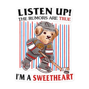 May include: A sticker featuring a cartoon teddy bear in a hockey uniform, holding a hockey stick and puck. The bear wears a gray helmet and jersey with the number 81. Text reads "LISTEN UP! THE RUMORS ARE TRUE I'M A SWEETHEART" with a red, white, and blue striped background.
