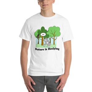 May include: White t-shirt with a cartoon image of a squirrel wearing roller skates in a forest setting. The text "Nature is Heelying" is printed below the image.