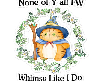 Puede incluir: Una pegatina con un gato de dibujos animados que lleva un sombrero de mago azul y sostiene una varita mágica. El gato está rodeado de una corona de hojas verdes y flores blancas. El texto "None of Y'all FW Whimsy Like I Do" está impreso en la pegatina.