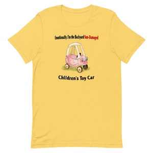 Könnte beinhalten: Ein gelbes T-Shirt mit einer Illustration eines rosafarbenen Spielzeugautos und dem Text "Emotional bin ich das sonnenbeschädigte Spielzeugauto im Garten".