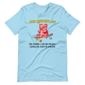 May include: Light blue t-shirt with a red gummy bear on a skateboard. The text "NICE ARGUMENT, BUT IDK WHERE I AM OR WHAT'S GOING ON AND I'M AFRAID" is printed on the shirt.