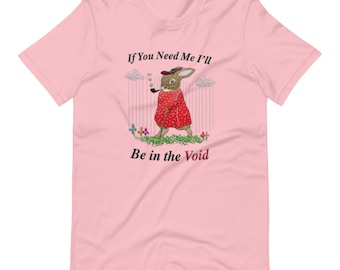 May include: Pink t-shirt featuring a whimsical illustration of a rabbit in a red coat, smoking a pipe, and holding a cane. The text on the shirt reads "If You Need Me I'll Be in the Void."