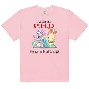 Könnte beinhalten: Hellrosa T-Shirt mit dem Text "I've Got That P.H.D. (Permanent Head Damage)". Die Grafik zeigt ein Cartoon-Kaninchen mit einer Boombox und Tanzpfeilen. Das Shirt hat einen lässigen Stil.