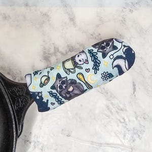 May include: A white ceramic mug with a wraparound design featuring a vibrant, colorful illustration of a toucan bird perched on a branch. The mug has a black handle and a glossy finish.