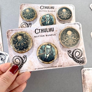 Könnte beinhalten: Ein Set mit sechs Cthulhu-Motiven. Die Knöpfe zeigen Illustrationen von Cthulhu, einem tentakelbewehrten Monster aus den Werken von H.P. Lovecraft, und einem Mann im Anzug. Die Knöpfe sind auf einer Karte mit einem Hintergrund im Vintage-Stil angeordnet. Die Karte trägt die Aufschrift "Cthulhu Button Bundle" und "Aileenstreasurebox.com".