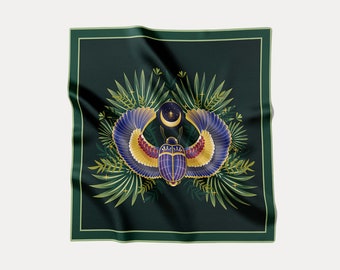May include: A green square scarf with a gold and blue scarab beetle with wings, a crescent moon, and stars. The beetle is surrounded by green leaves.