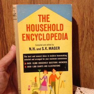 May include: A yellow and blue book titled "The Household Encyclopedia" compiled and edited by N.H. and S.K. Mager. The book cover features illustrations of a woman and a man in a home setting with a vacuum cleaner, a rake, and a ladder.