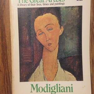 May include: A book cover from "The Great Artists" series, featuring a portrait by Modigliani. The cover has the title in green, with the artist's name below the portrait. The portrait depicts a woman with a long neck and blue eyes.