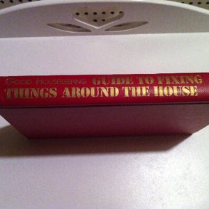 May include: A red hardcover book titled "Good Housekeeping Guide to Fixing Things Around the House".