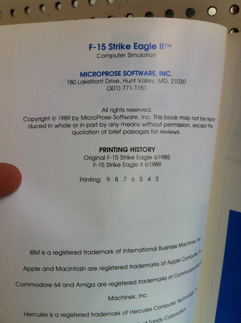 May include: A black and white printed page with the title "F-15 Strike Eagle II" and the text "MICROPROSE SOFTWARE, INC."  The page includes copyright information and a printing history for the F-15 Strike Eagle II computer simulation.