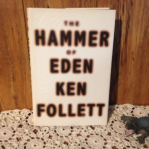 May include: The Hammer of Eden by Ken Follett, a white paperback book with black text.