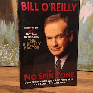 May include: A black book with a red title "The No Spin Zone" by Bill O'Reilly. The book cover features a photo of Bill O'Reilly and the text "Confrontations with the powerful and famous in America".