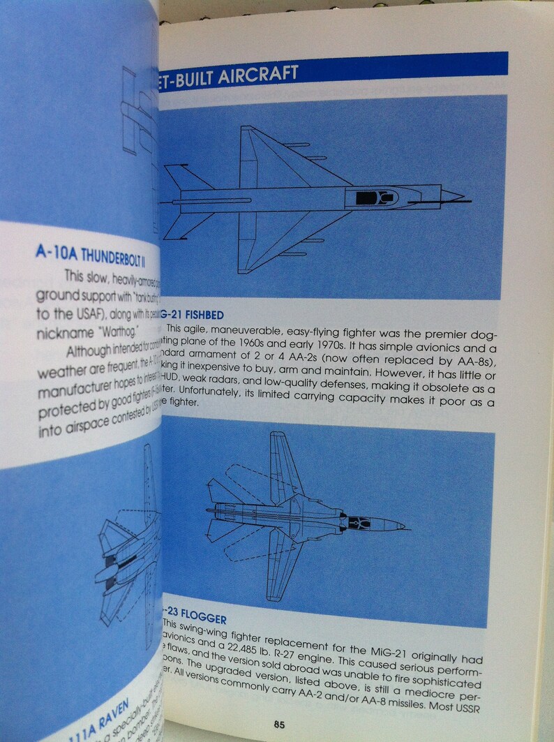 May include: A page from a book about military aircraft. The page features illustrations of three fighter jets: the A-10A Thunderbolt II, the MiG-21 Fishbed, and the MiG-23 Flogger. The text describes the capabilities and limitations of each aircraft.