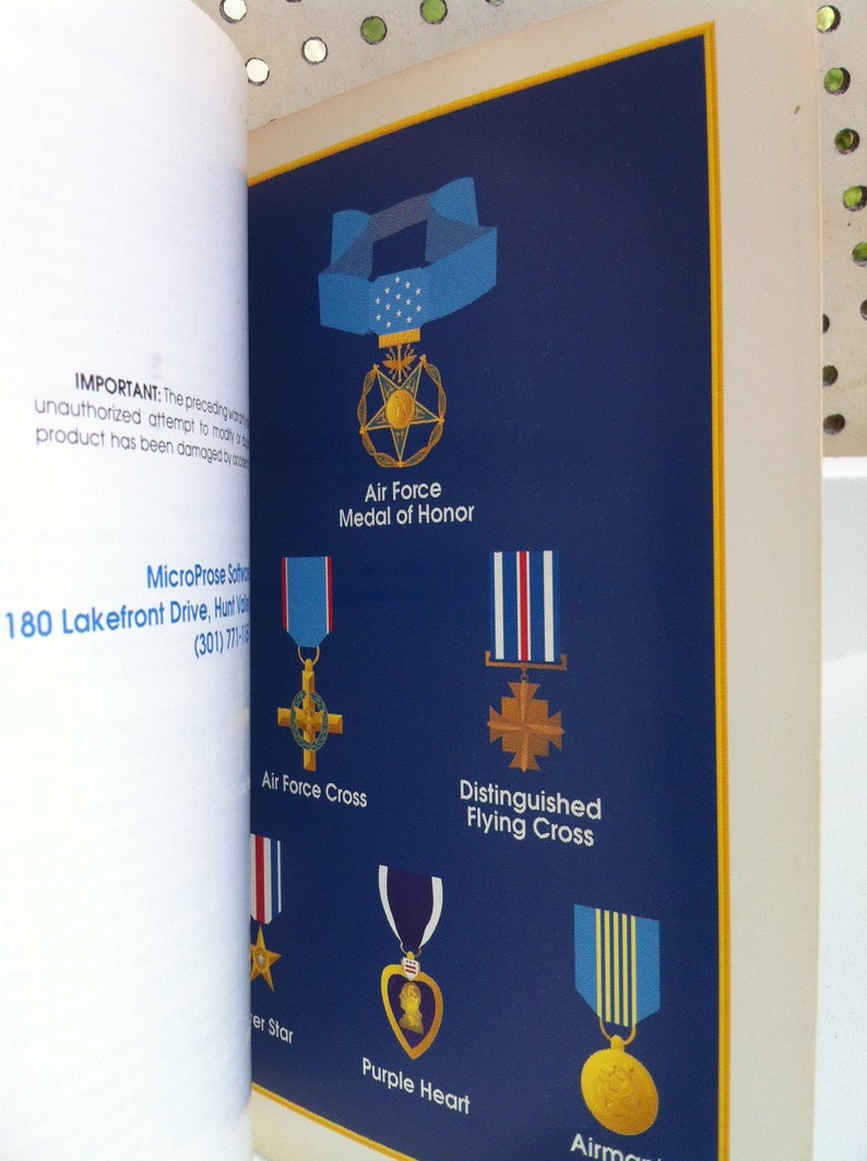 May include: A blue background with illustrations of different military medals, including the Air Force Medal of Honor, Air Force Cross, Distinguished Flying Cross, Purple Heart, and Airman's Medal. The text "IMPORTANT: The preceding warning...product has been damaged by unauthorized attempt to modify it." is visible at the top left corner of the image.