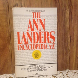 May include: A hardcover copy of "The Ann Landers Encyclopedia A-Z" is displayed. The book has a white cover with red lettering and a yellow sticker. The book's title and author are prominently featured.