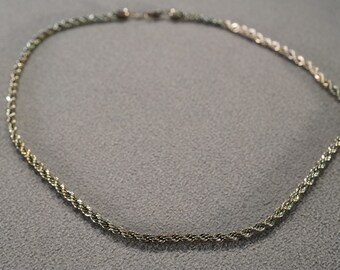 May include: A silver and gold rope chain necklace. The chain is made of two different metals, twisted together.