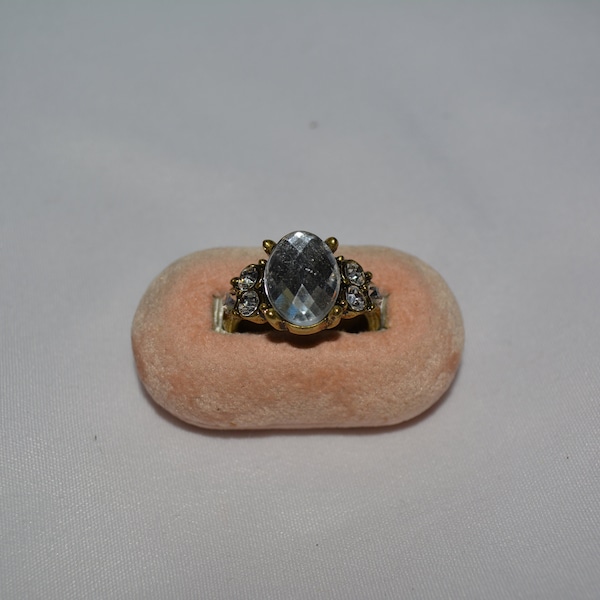 vintage gold tone statement ring with a large clear white oval lucite stone in the center flanked by three stones on each side, size 8 **M10