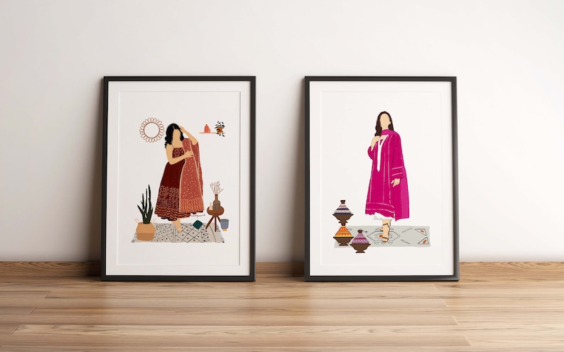 May include: Two framed art prints. One features a woman in a maroon dress with a patterned shawl. The other shows a woman in a pink outfit. Both prints have a minimalist style with decorative elements.