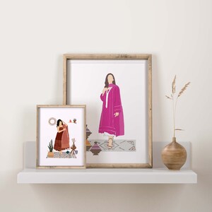 May include: Two framed art prints featuring illustrations of figures in traditional clothing. The larger print shows a woman in a pink outfit, while the smaller one depicts a woman in a red outfit. The prints are displayed on a white shelf with a vase.