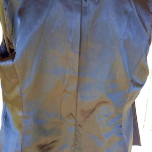 May include: Black blazer with a blue trim and a black lace collar. The blazer has a satin lining.