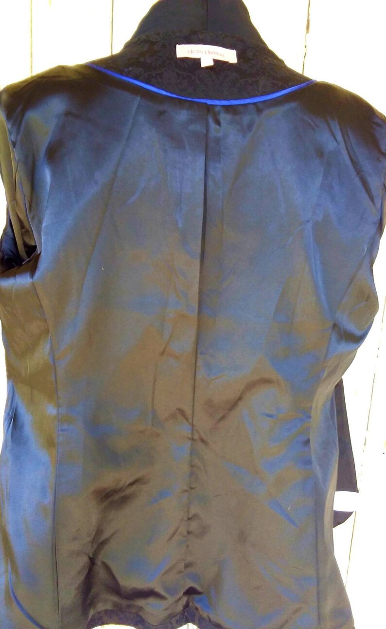 May include: Black blazer with a blue trim and a black lace collar. The blazer has a satin lining.