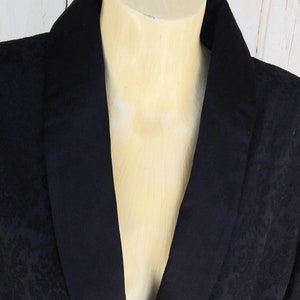 May include: A black blazer with a satin collar. The blazer has a subtle damask pattern.