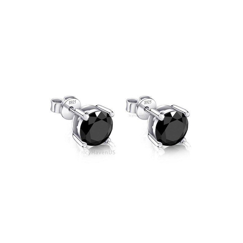 May include: A pair of silver stud earrings with black round gemstones. The earrings are marked with "S925" on the back.