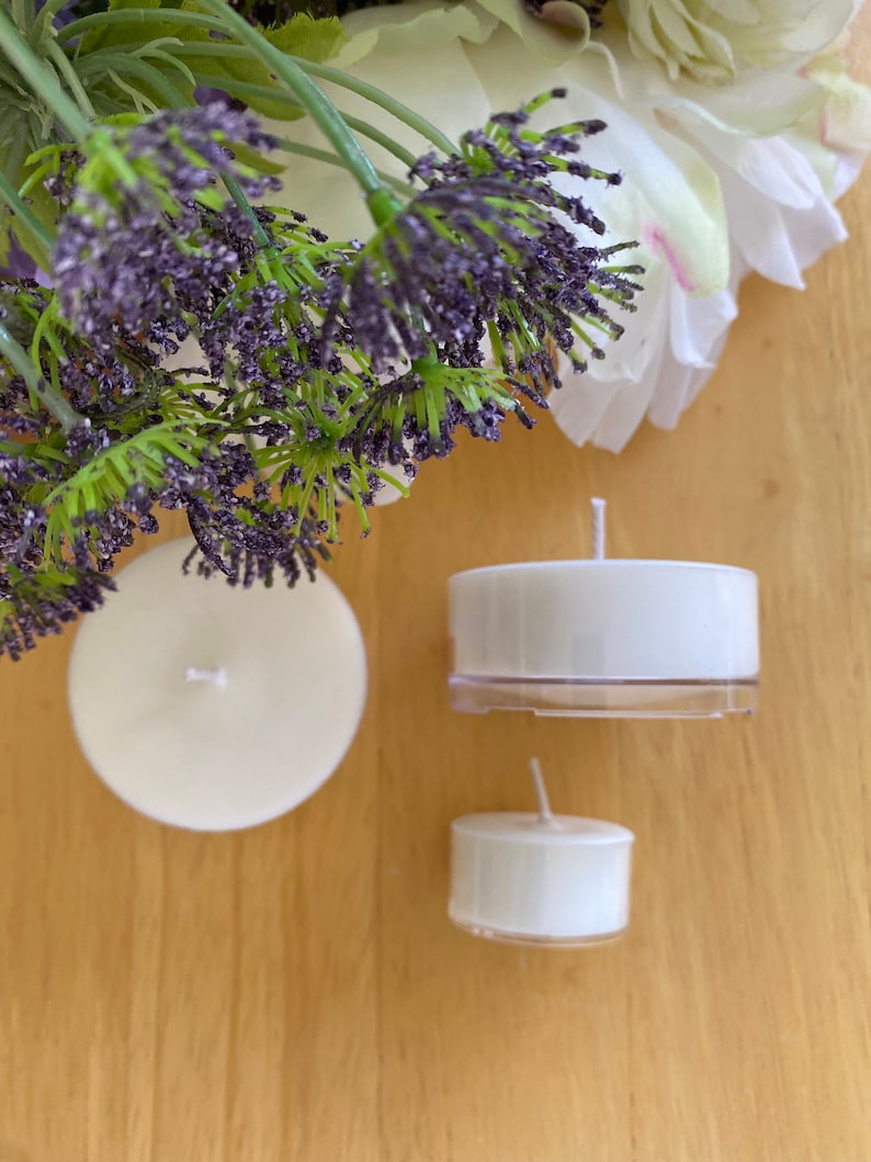 Peut inclure: Plusieurs bougies chauffe-plat blanches avec m&egrave;ches, dispos&eacute;es sur une surface en bois. Les bougies sont accompagn&eacute;es de lavande artificielle et de fleurs blanches, cr&eacute;ant une esth&eacute;tique calme et naturelle.