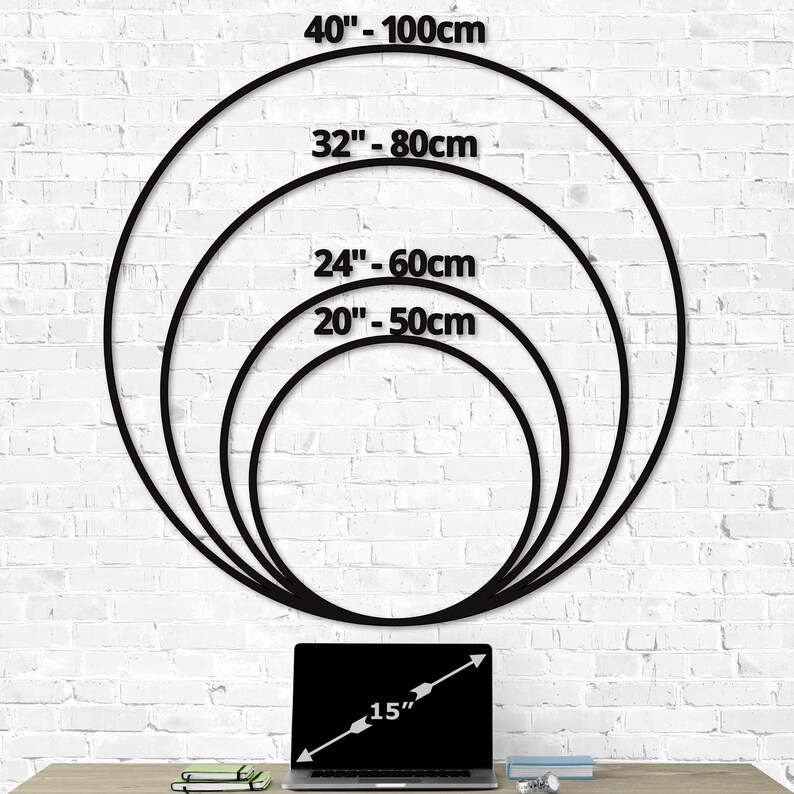 Wall clock size chart showing multiple dimensions of 20 inch, 24 inch, 32 inch, and 40 inch diameters compared to a 15 inch laptop, clear sizing guide for large metal wall clocks on a white brick wall backdrop for easy home decor planning.
