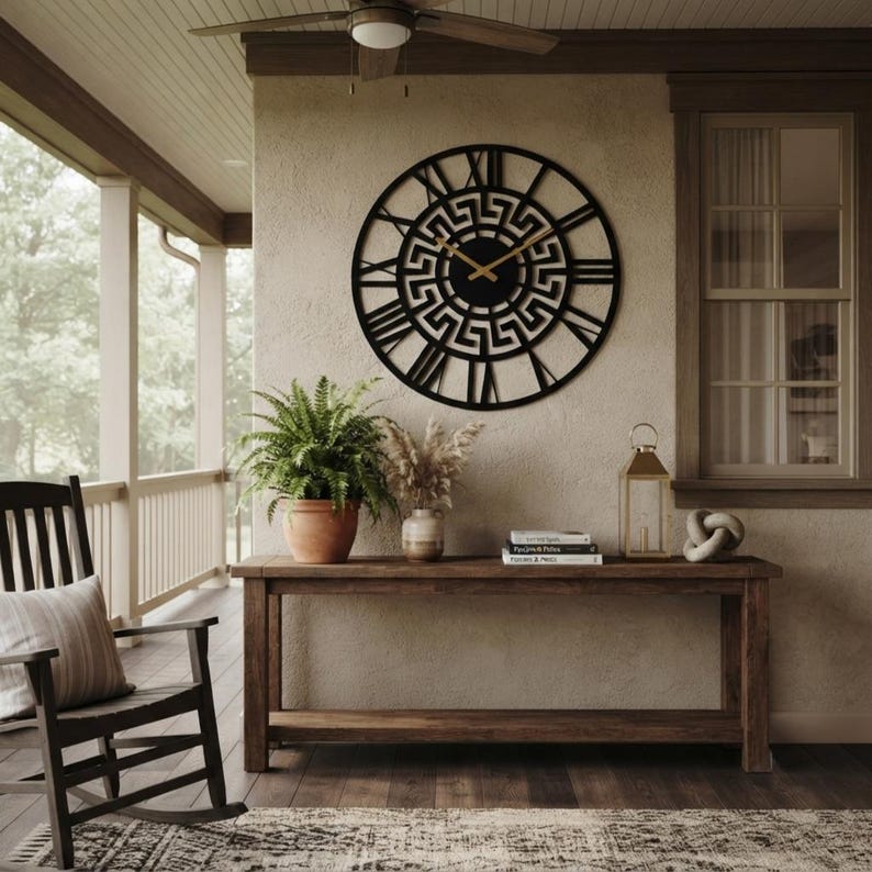 Large Meander metal wall clock with an ancient Greek key pattern, stylish black steel wall art decor displayed on a rustic farmhouse porch.