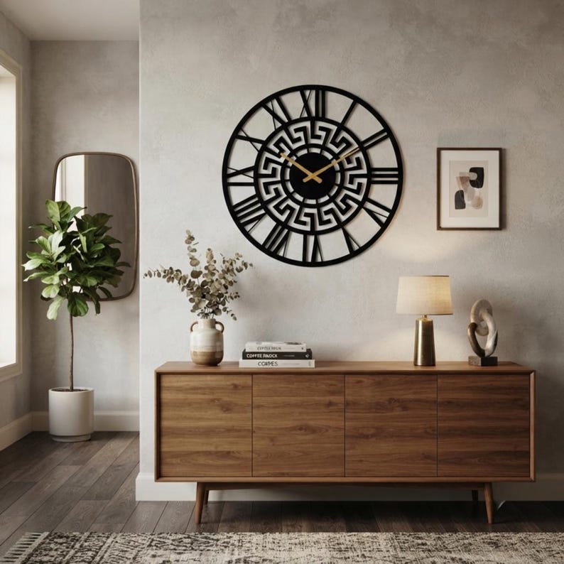 Large Meander metal wall clock featuring an ancient Greek key pattern, modern black steel wall art decor hanging above a wooden console table in a stylish home interior.