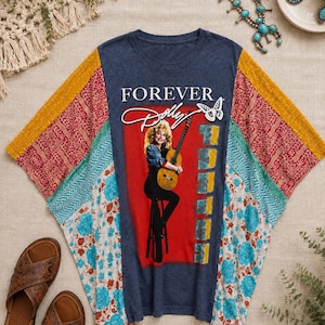 May include: A navy blue t-shirt featuring a graphic of a person playing an acoustic guitar on a stool with the text FOREVER DOLLY. The shirt has multi-colored patchwork sleeves with floral, geometric, and dotted patterns in red, teal, and yellow.