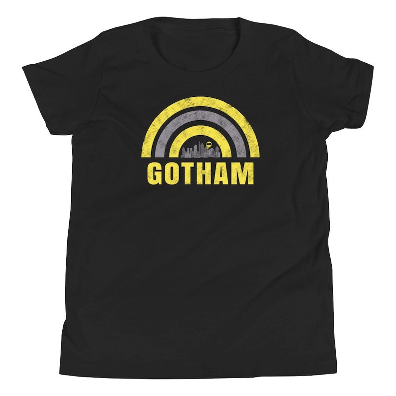 May include: Black youth t-shirt featuring a yellow and grey distressed rainbow graphic with the word "GOTHAM" in yellow text.