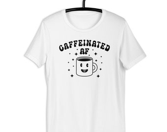 May include: White t-shirt with black text that reads "caffeinated af" and a cartoon coffee cup with a smiley face.