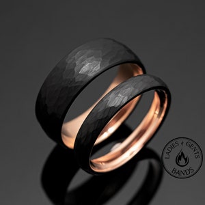 Peut inclure: Deux alliances noires martelées avec un intérieur en or rose. Les bagues sont présentées sur une surface réfléchissante. Les anneaux ont une surface texturée et un design moderne. Le logo "Ladies & Gents Bands" est visible.