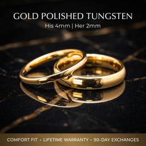 May include: Two gold polished tungsten rings. The text on the image reads: "GOLD POLISHED TUNGSTEN His 4mm | Her 2mm". The rings are on a black marble surface. The rings are reflected in the surface.