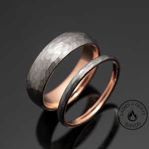 May include: Two wedding bands, one with a hammered finish in black and the other in rose gold. The bands are stacked on top of each other.