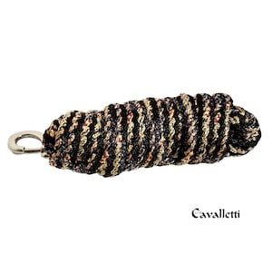 Op de afbeelding: Een gevlochten touw met een zilverkleurige clip. Het touw is zwart, goud en rood. Het woord "Cavalletti" staat in zwart schrift rechtsonder in de afbeelding. Dit touw wordt waarschijnlijk gebruikt voor paardensportactiviteiten.