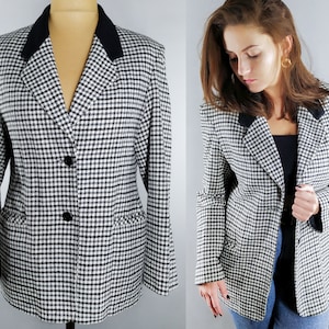 Può includere: Un blazer gingham bianco e nero con colletto nero. Il blazer ha una chiusura a due bottoni e due tasche.