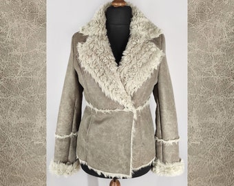 May include: A brown faux fur jacket with a white faux fur collar and cuffs. The jacket has a  asymmetrical zipper closure and a belt at the waist.