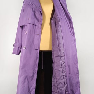 May include: A long purple coat with a double breasted closure and a quilted lining.