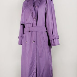 May include: A long, purple trench coat with a double-breasted closure, a belt, and a collar.