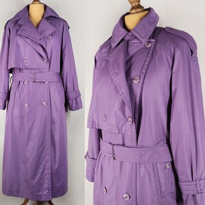 May include: A long, purple trench coat with a double-breasted closure, a belt, and a storm flap. The coat has a classic design and is made of a smooth, lightweight fabric.