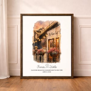 Puede incluir: Impresión artística enmarcada con una ilustración en acuarela de The River Cafe en Nueva York al anochecer. La impresión incluye los nombres "Francis & Udelia" y la fecha "12 de junio de 2018". La obra de arte está enmarcada en un marco de madera oscura.